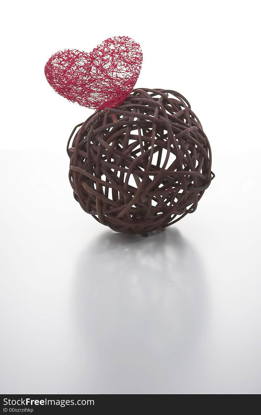 Wicker ball with a red heart made of artificial fiber