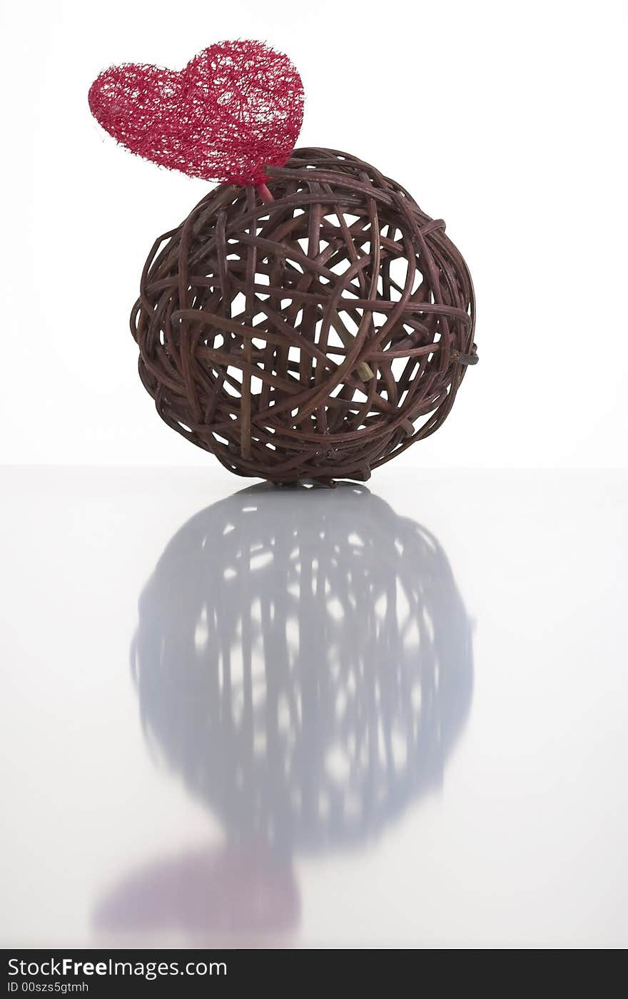 Wicker ball with a red heart made of artificial fiber