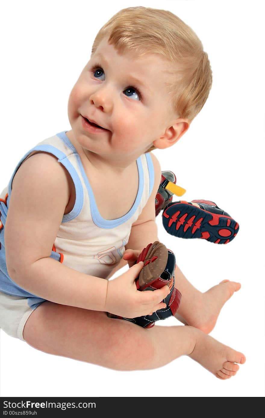 The beautiful little boy tries on footwear. The beautiful little boy tries on footwear