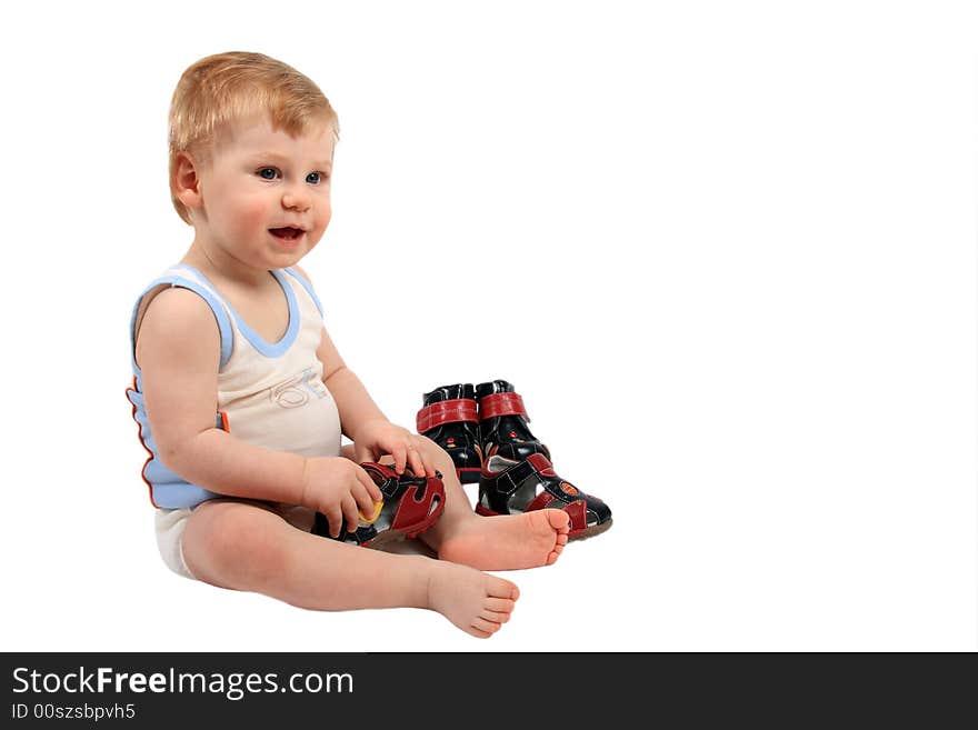 The beautiful little boy tries on footwear. The beautiful little boy tries on footwear