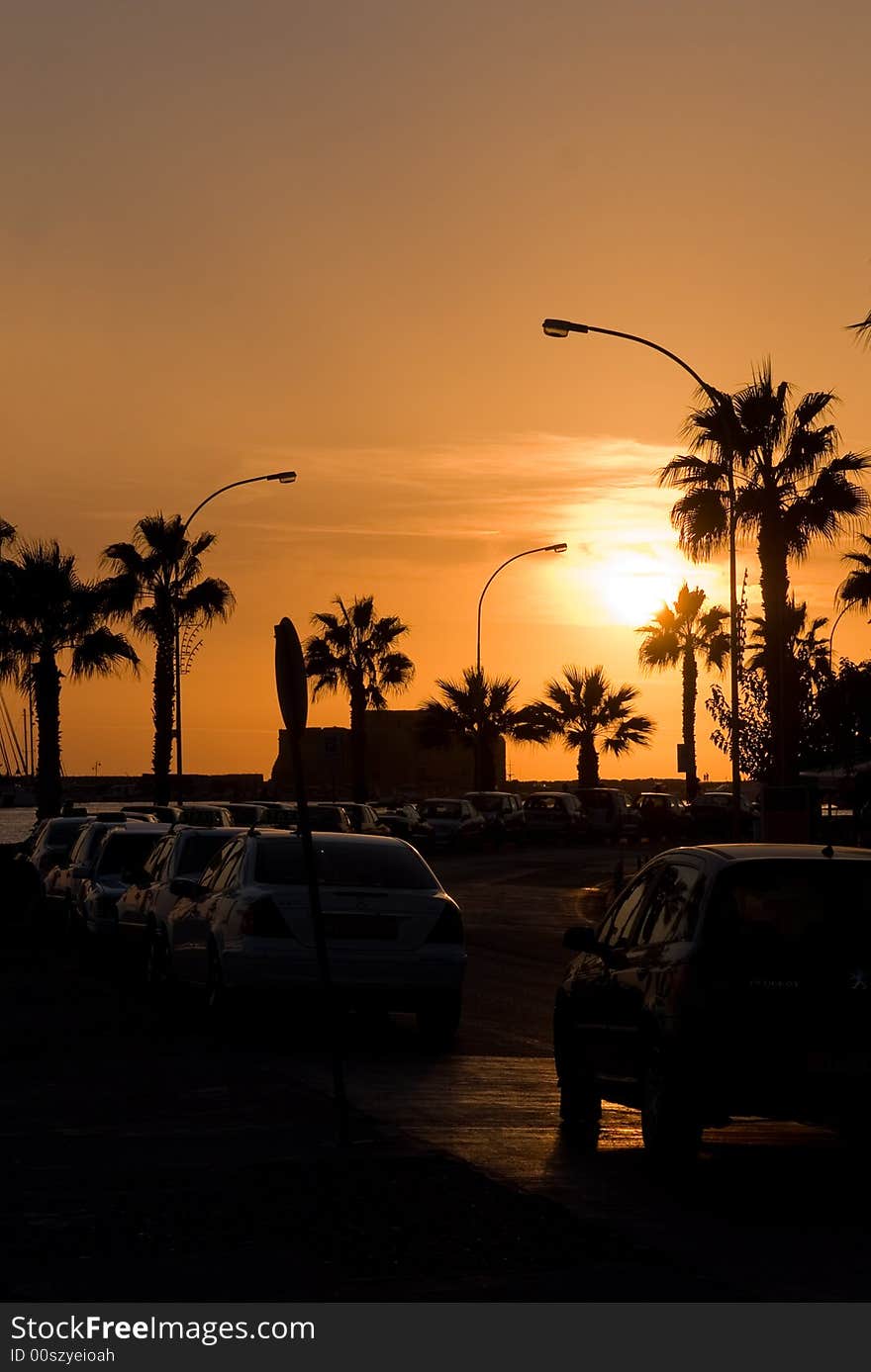 Yellow sunset with cars, palms and lampposts. Yellow sunset with cars, palms and lampposts