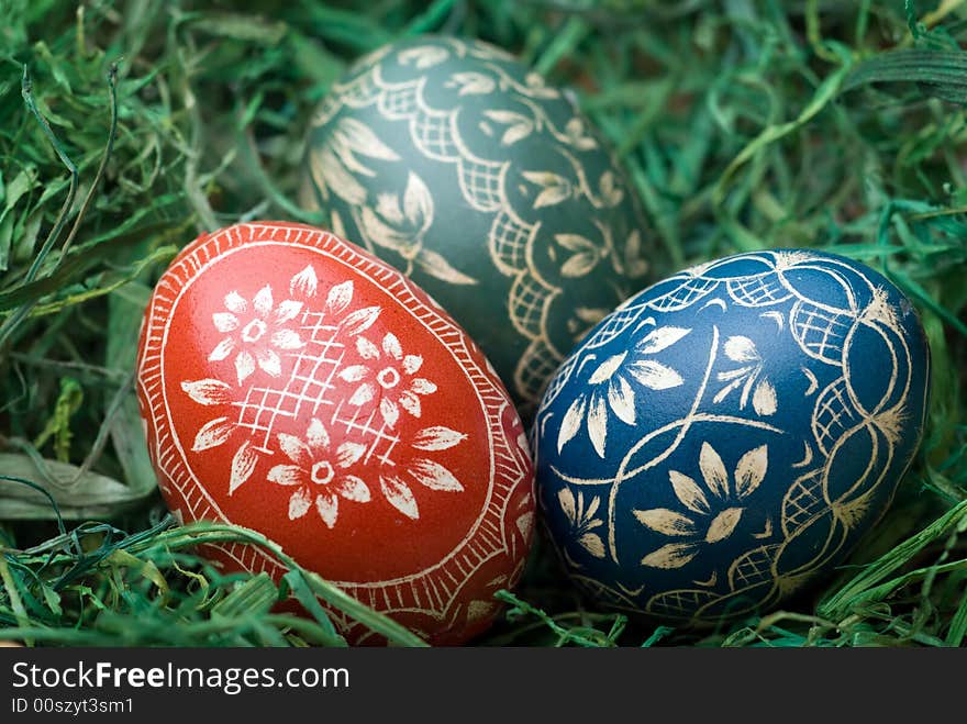 Three handmade easter eggs on the green hay. Selective focus, shallow depth of field. Three handmade easter eggs on the green hay. Selective focus, shallow depth of field.