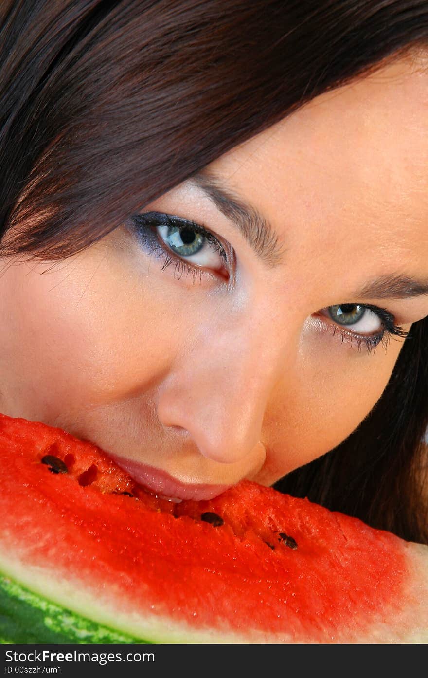 Beautiful brunette eating a melon