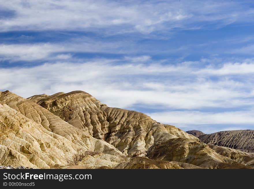 Mountains with the blue lightly clouded sky in the background. Mountains with the blue lightly clouded sky in the background