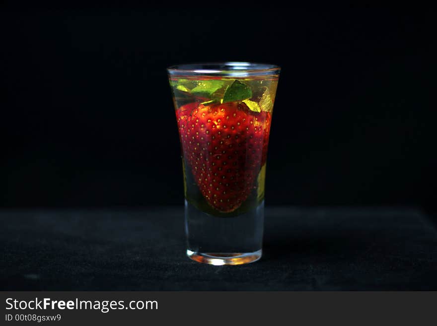 Honey soaked strawberry in glass on dark background. Honey soaked strawberry in glass on dark background.