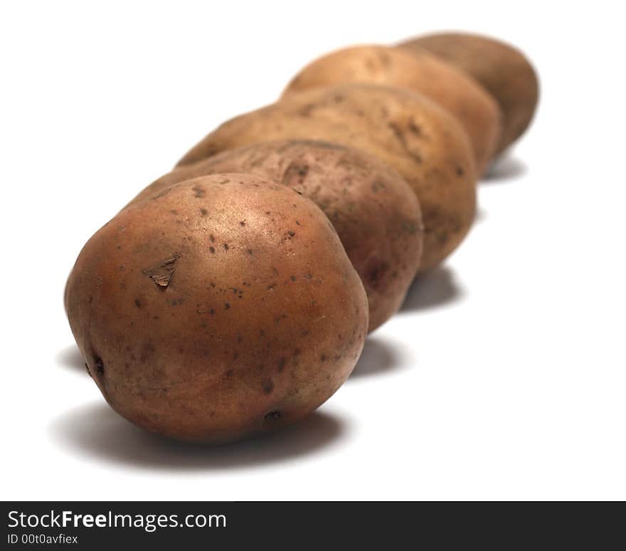 Organic raw potatoes in a row, isolated on white background. Organic raw potatoes in a row, isolated on white background.