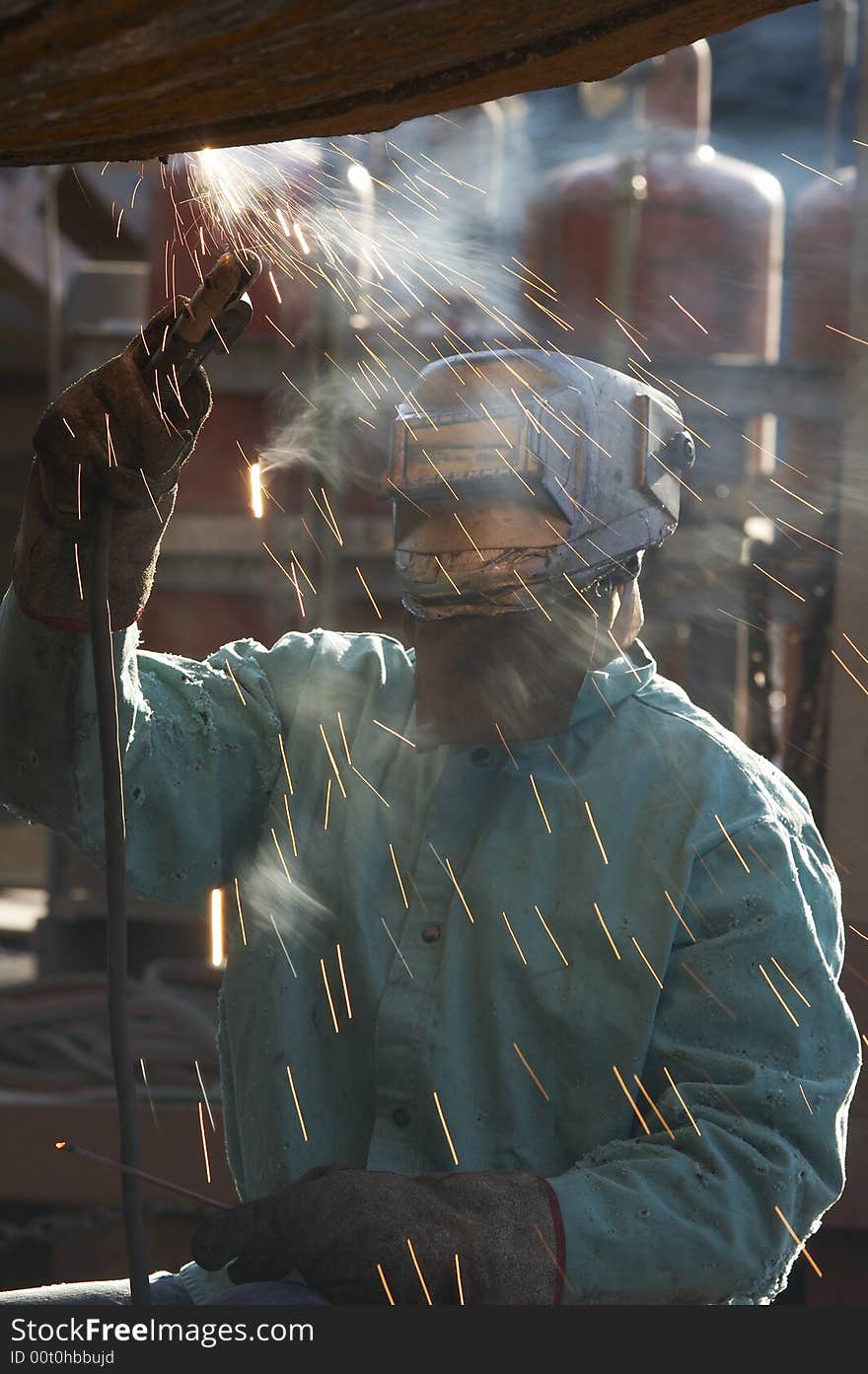 A welder working at shipyard on dayshift. A welder working at shipyard on dayshift