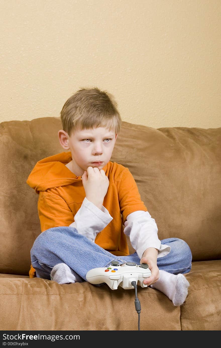 Here is a picture of a young boy playing a video game. Here is a picture of a young boy playing a video game.