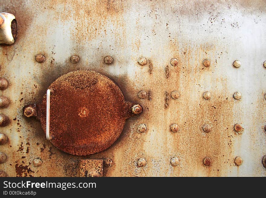 Detail of the rusty steel hatch on an old industrial boiler. Detail of the rusty steel hatch on an old industrial boiler