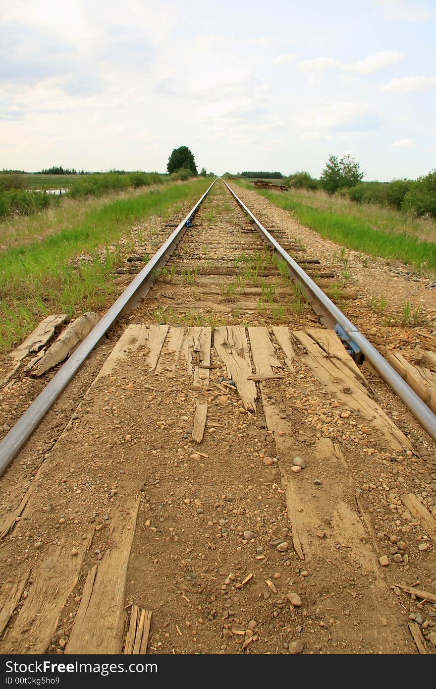 Railroad tracks stretching accross the prairies into the big blue sky. Railroad tracks stretching accross the prairies into the big blue sky