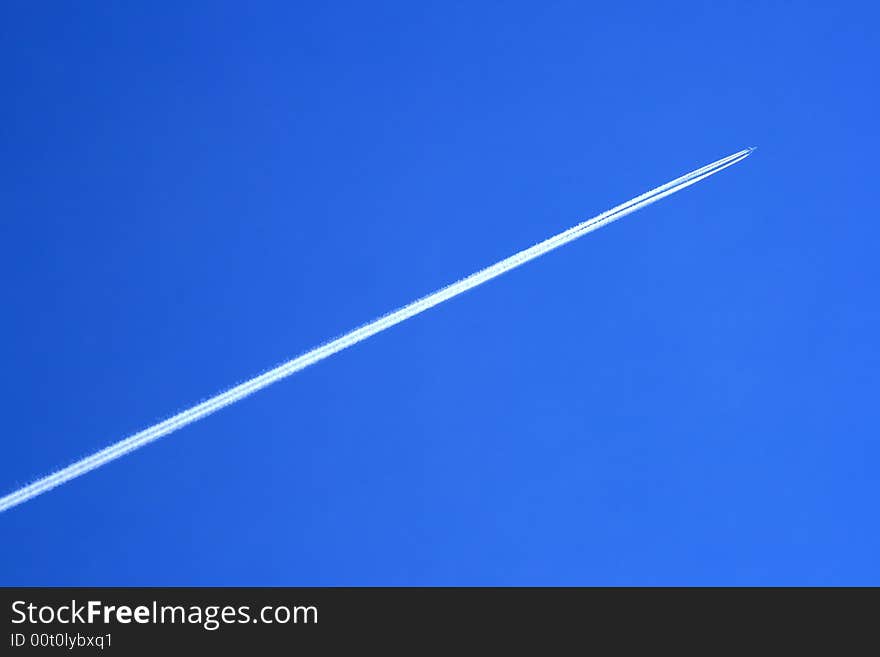 Vapour trail of a large jetliner streaking across a clear blue sky. Vapour trail of a large jetliner streaking across a clear blue sky