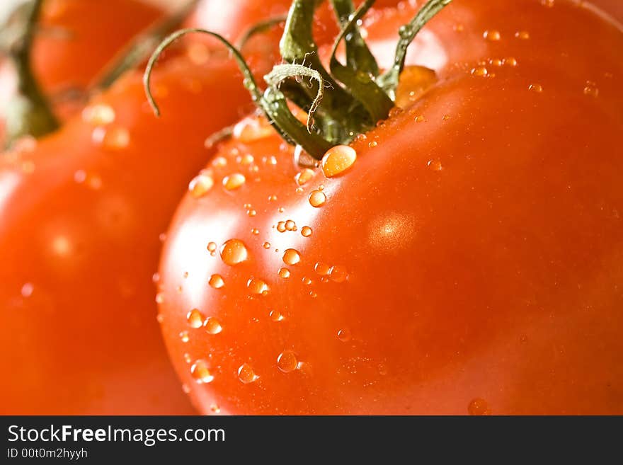 Fresh red ripe tomatoes with water drops shot with a macro lens. Fresh red ripe tomatoes with water drops shot with a macro lens