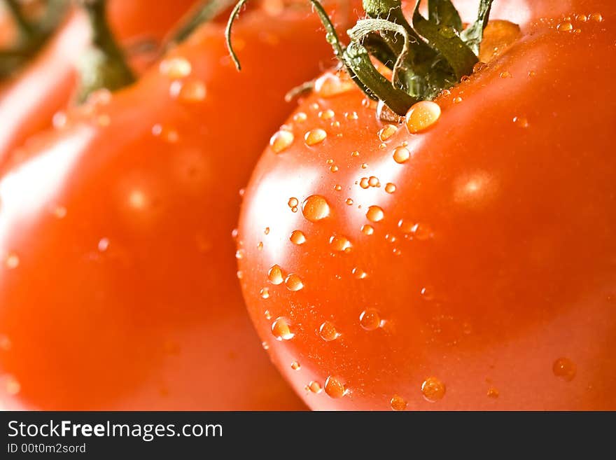 Fresh red ripe tomatoes with water drops shot with a macro lens. Fresh red ripe tomatoes with water drops shot with a macro lens