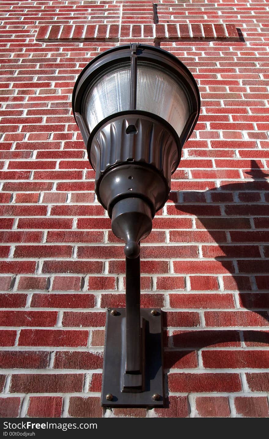 This lamp is on the outside of a church building. This lamp is on the outside of a church building.