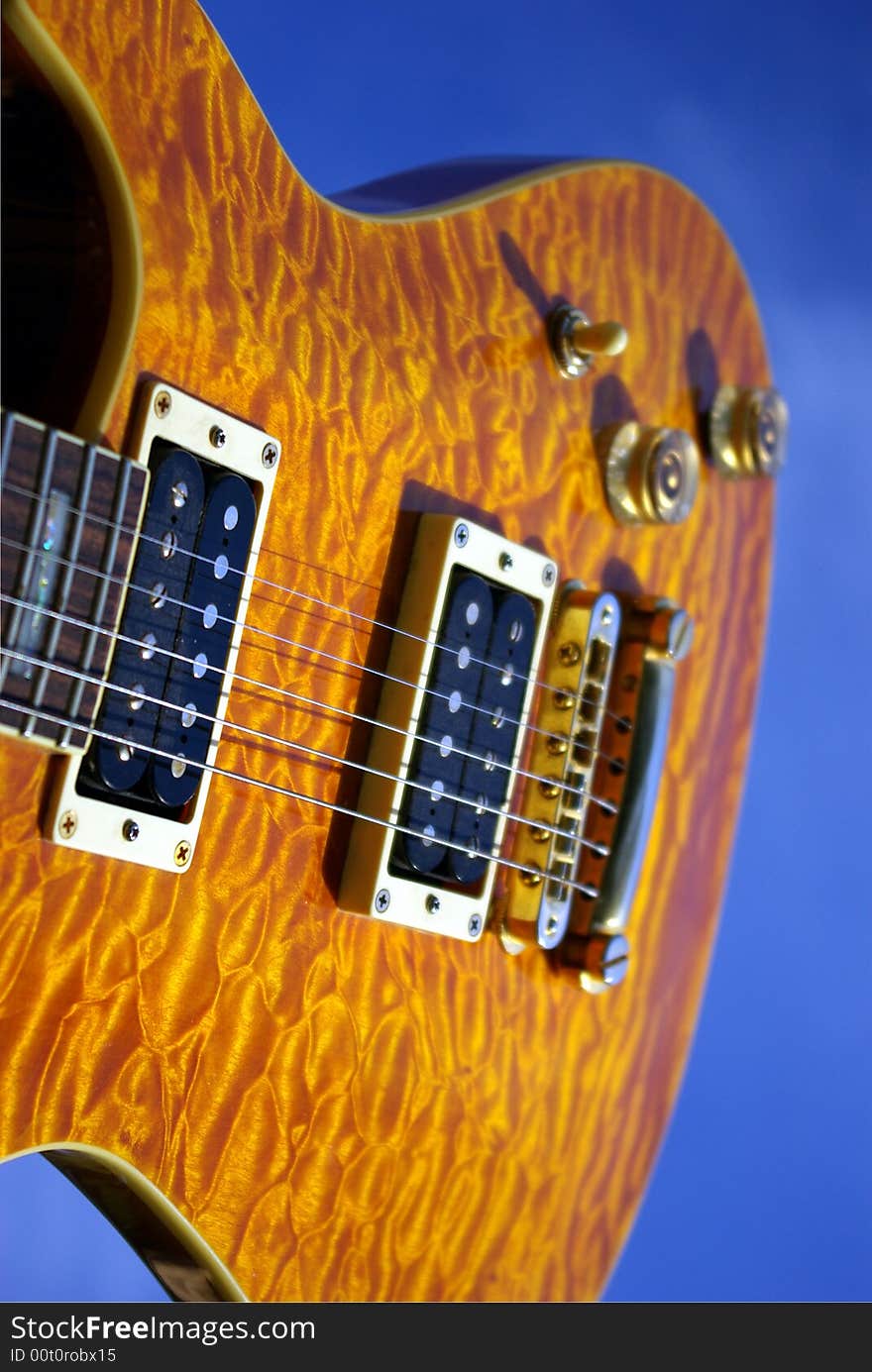 A pillow maple guitar body against a blue sky