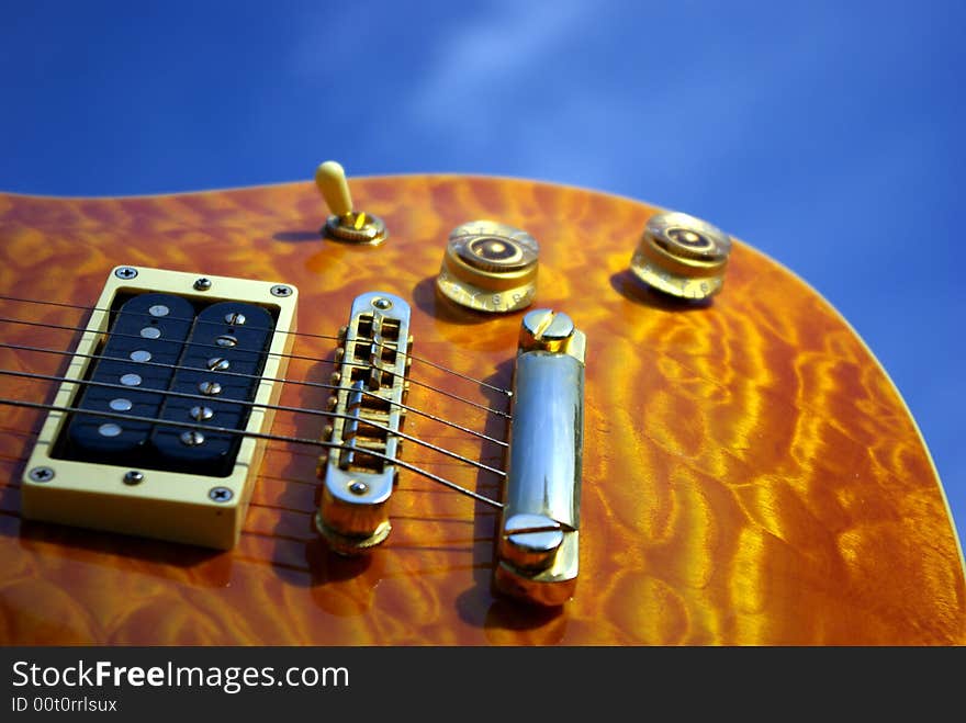 A pillow maple guitar body against a blue sky