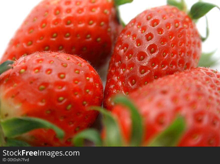 Close-up of brightly red strawberries on a white background.