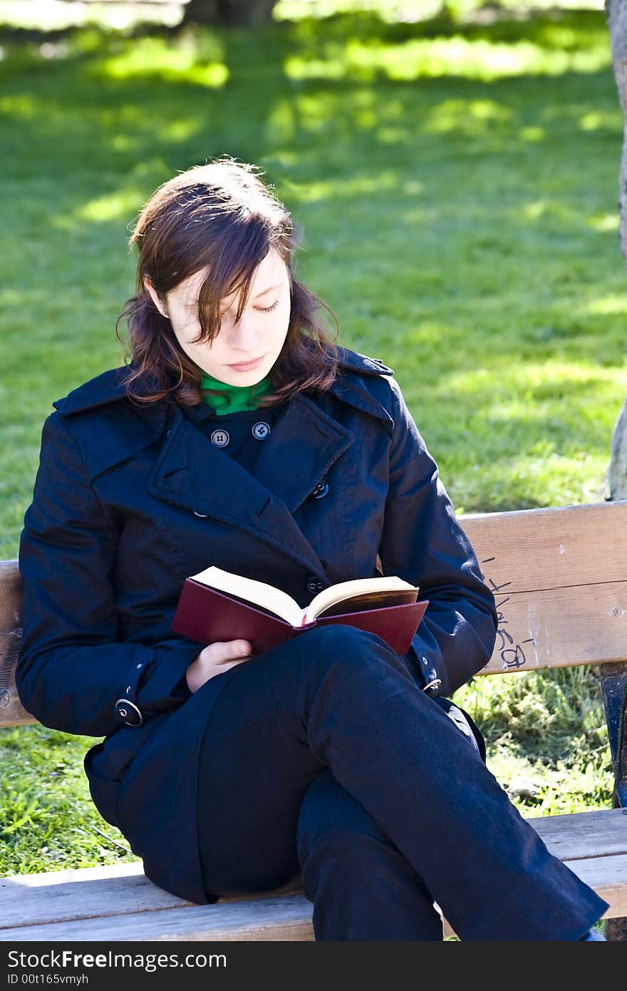 Young woman enjoying a book in the park. Young woman enjoying a book in the park