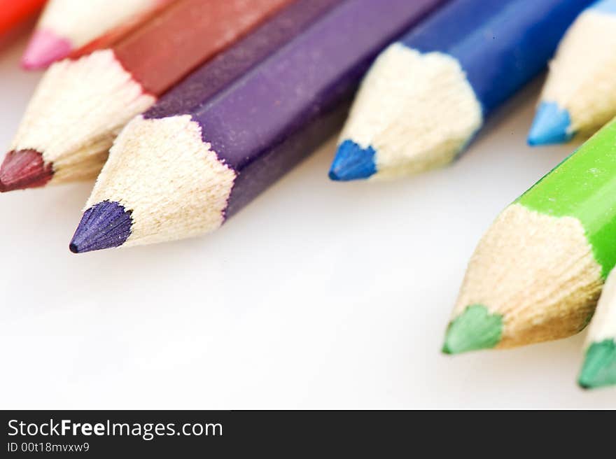 Pencils in different colors. Pencils placed uneven. focus on purple pencil. Pencils in different colors. Pencils placed uneven. focus on purple pencil.