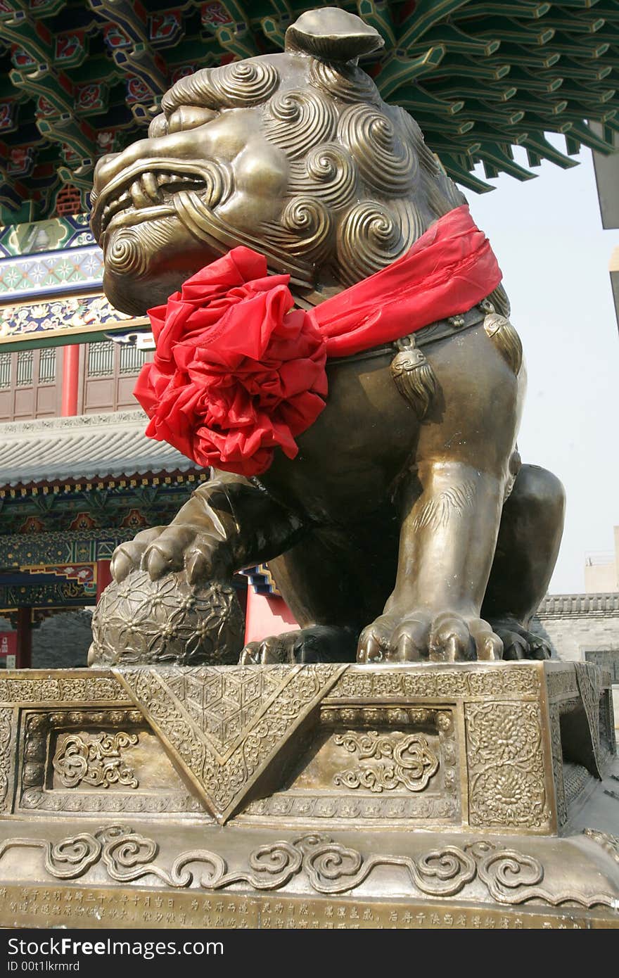 A golden lion sulpture in front of a ancient temple.Xian,China. A golden lion sulpture in front of a ancient temple.Xian,China.