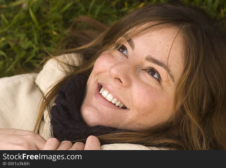 Portrait of a naturally beautiful wondering girl in a green meadow in the early spring. Portrait of a naturally beautiful wondering girl in a green meadow in the early spring