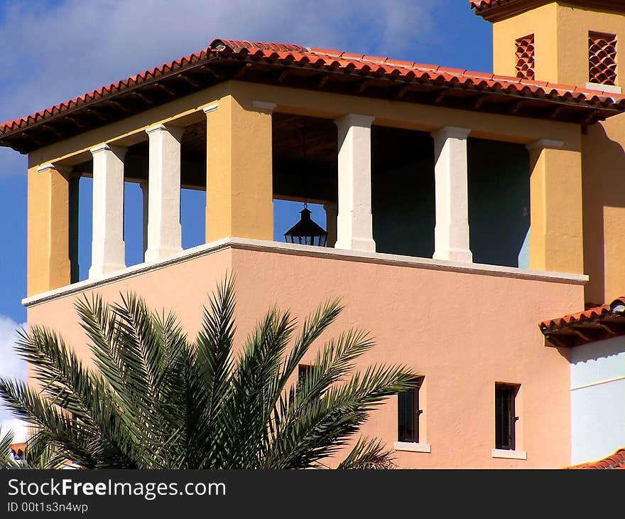 Top of palm tree by upper part of spanish style building