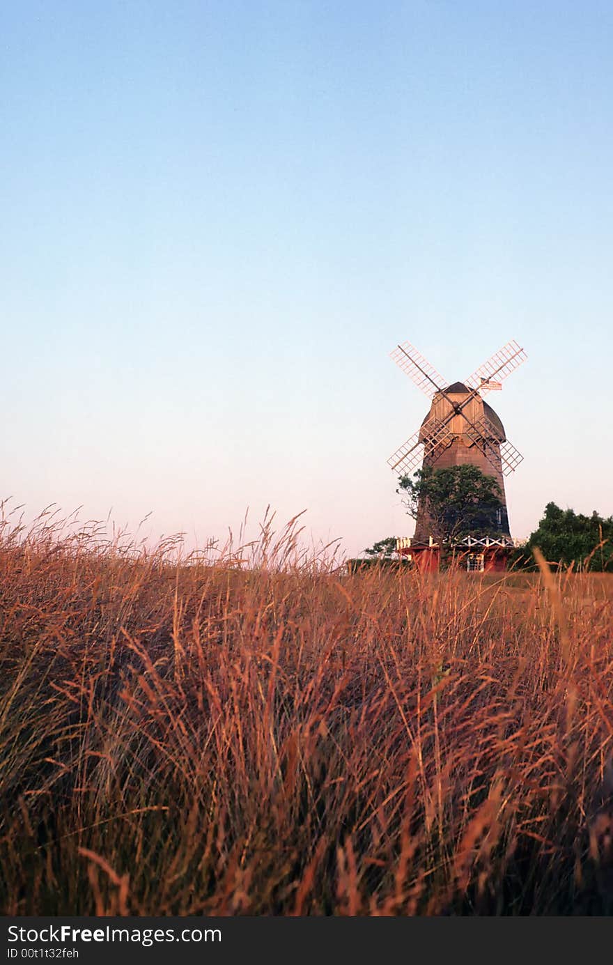 A windmill sits in this field ready to do its job for the farmer. A windmill sits in this field ready to do its job for the farmer