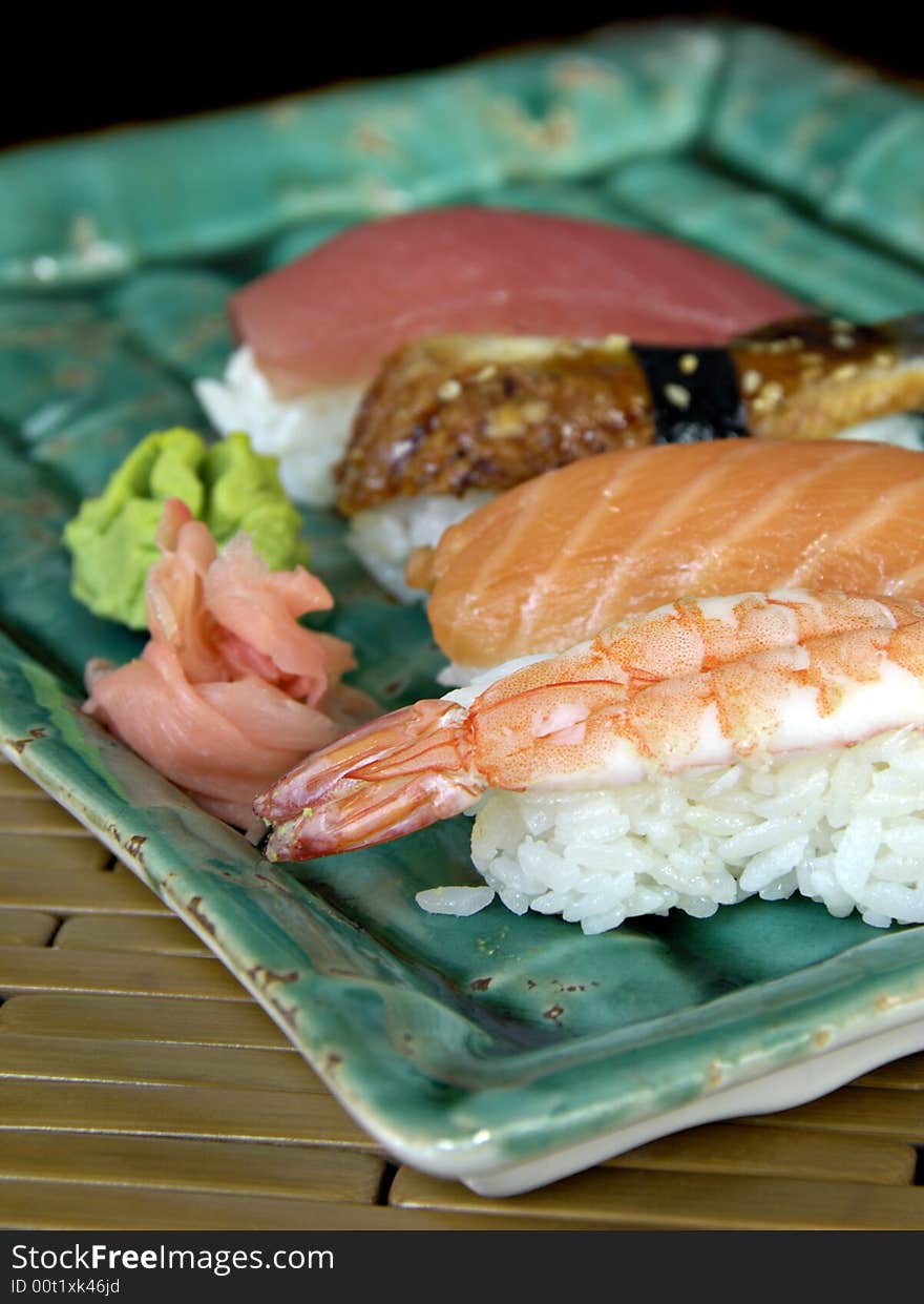 Different types of sushi lined up on a plate. Different types of sushi lined up on a plate.