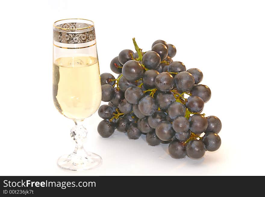 Glass of white wine and bunch of the black grapes, isolated on a white background. Glass of white wine and bunch of the black grapes, isolated on a white background