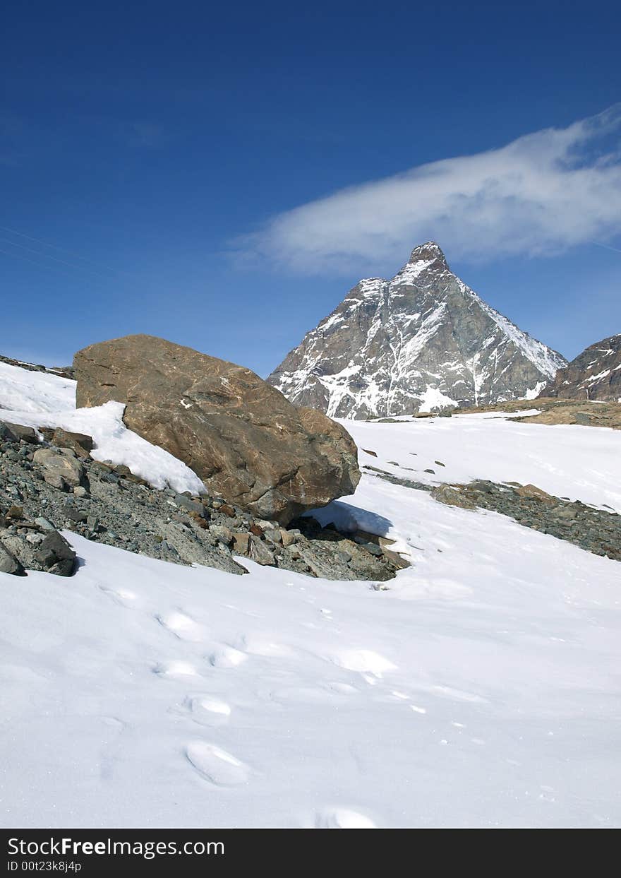 The big warm stone in a snow, on a background of Matterhorn