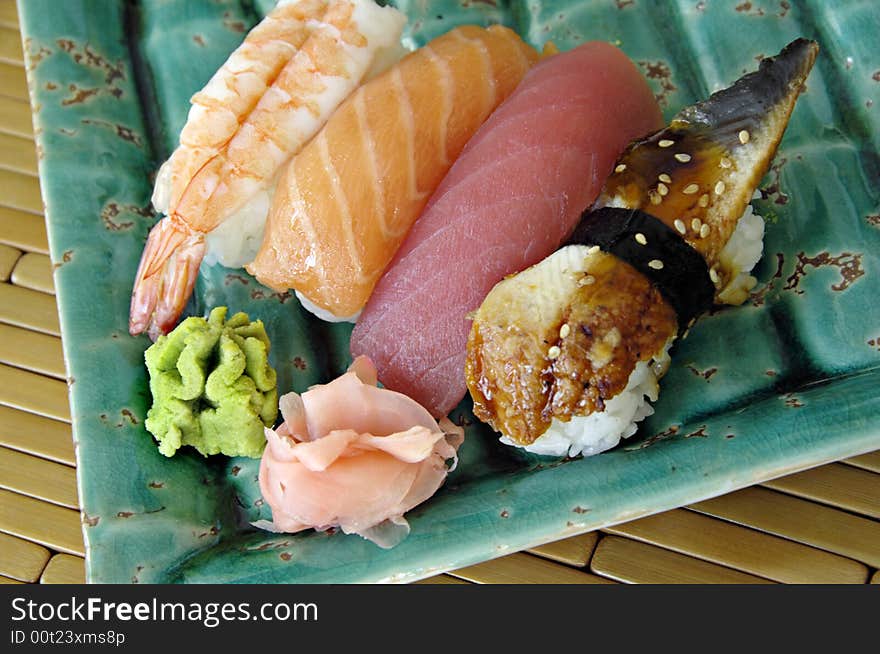 Different types of sushi lined up on a plate. Different types of sushi lined up on a plate.