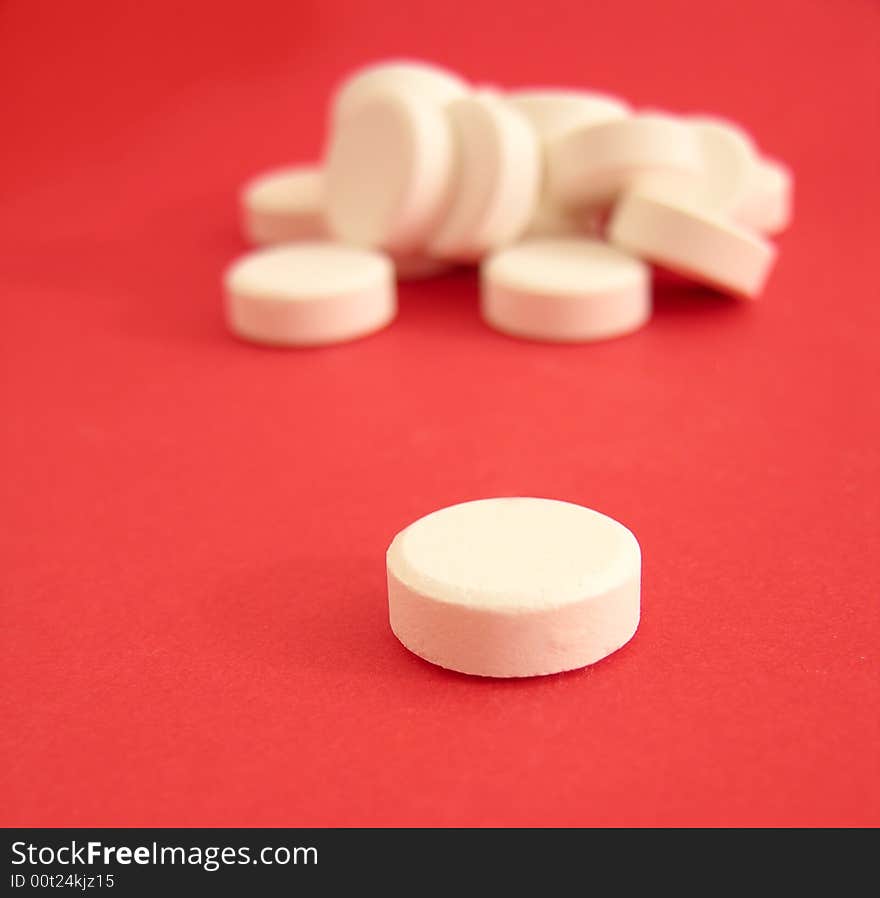 White tablets on the red background