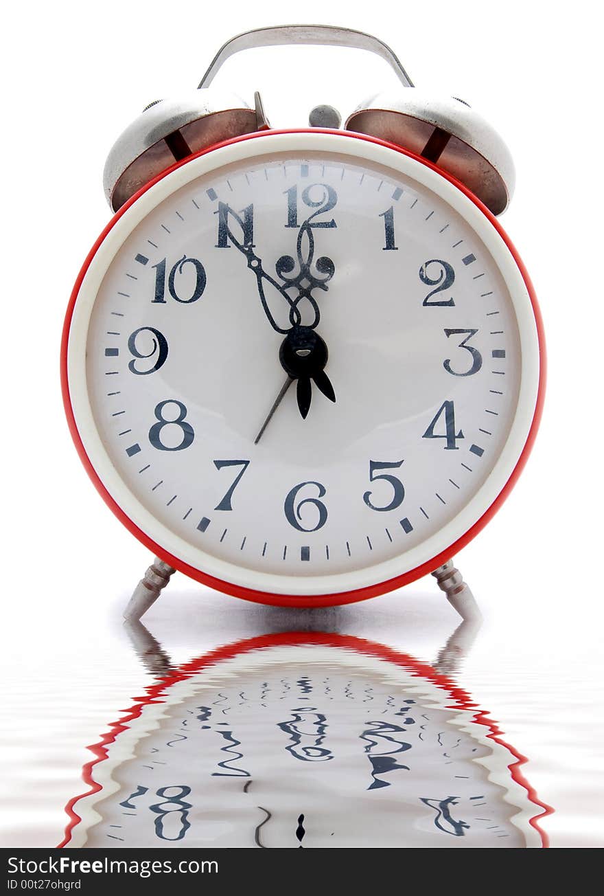 Old red alarm clock on a white background