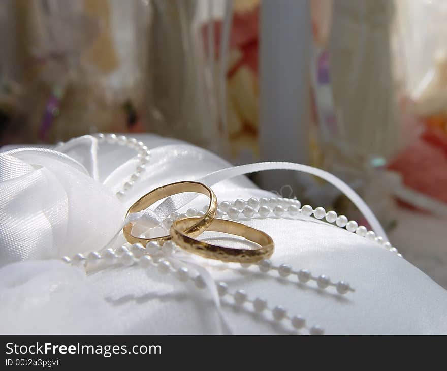 Two intertwined wedding rings resting on a pillow before a wedding. Two intertwined wedding rings resting on a pillow before a wedding