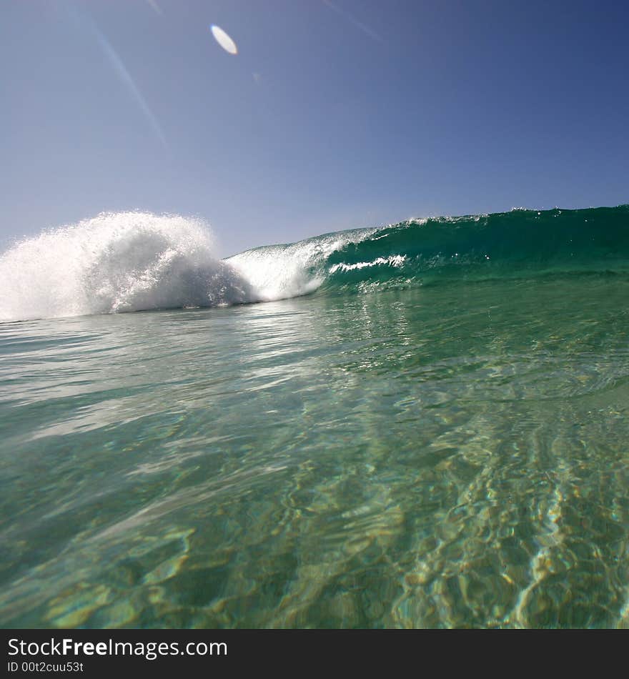 A wave breaking along the sea shore. A wave breaking along the sea shore.