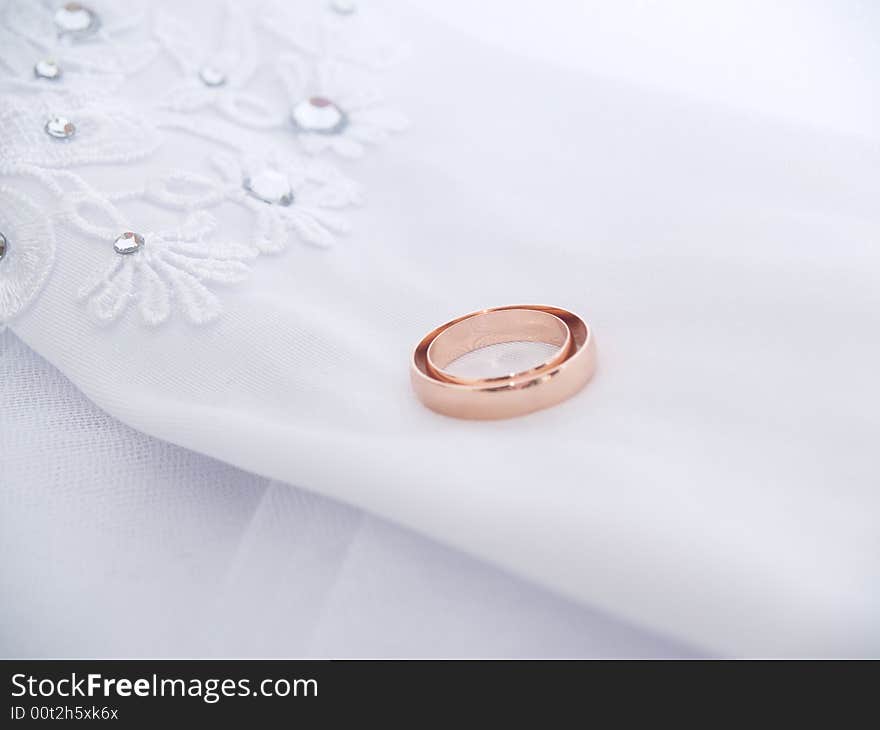 Closeup of wedding rings on a white glove