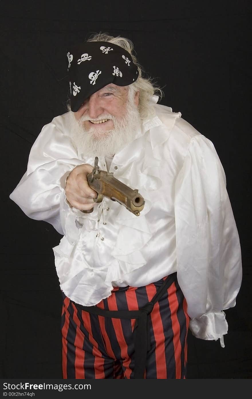 An old man dressed as a pirate with a gun. An old man dressed as a pirate with a gun