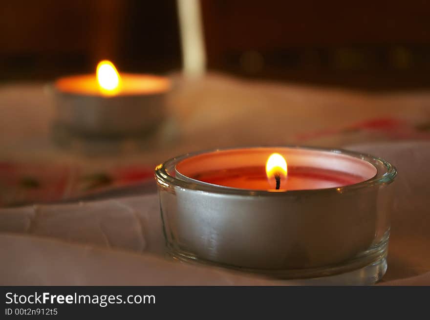 Two votive candles are burning on decorated table. Two votive candles are burning on decorated table.