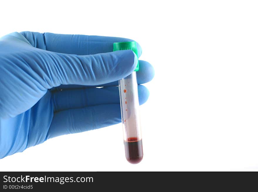 Gloved hand with red liquid filled test tube. Gloved hand with red liquid filled test tube