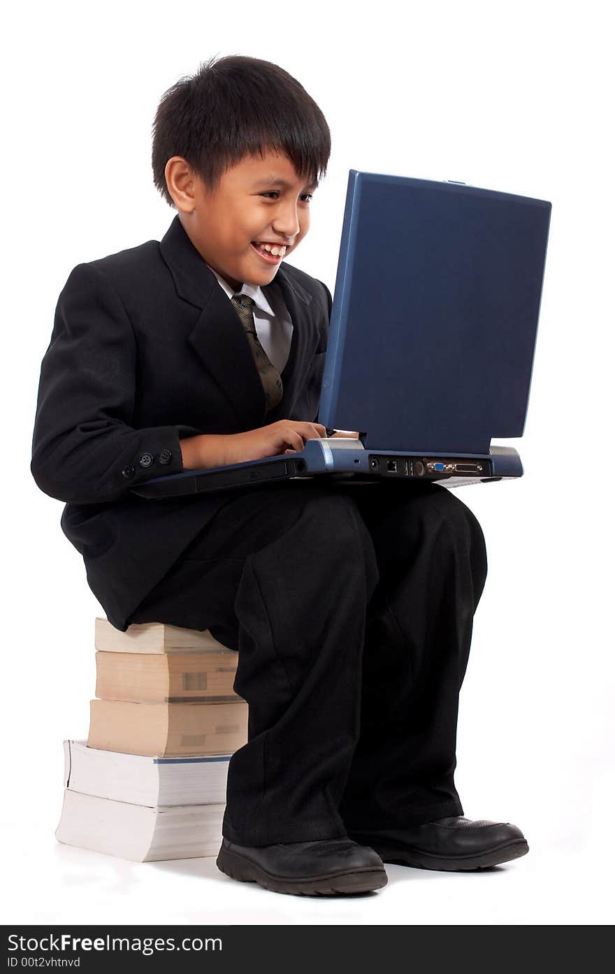 Young businessman with laptop sitting on a stack of books