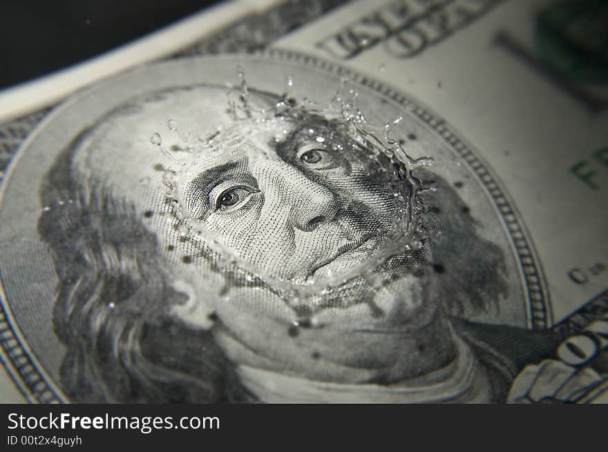 Water droplet impacting 100 dollar bill. Water droplet impacting 100 dollar bill