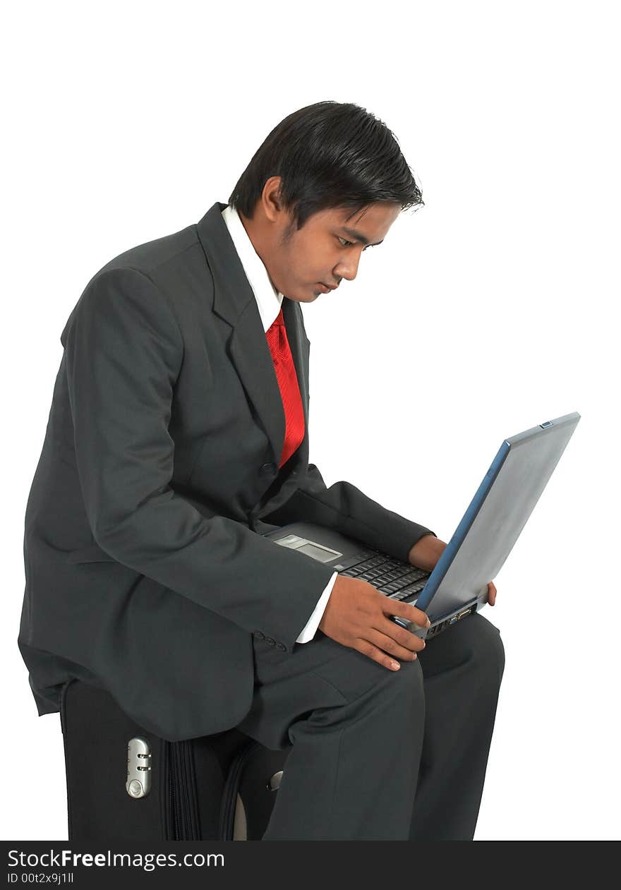 A man sitting on his luggage over a white background. A man sitting on his luggage over a white background