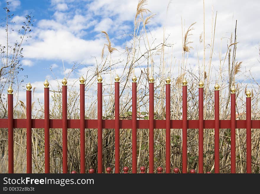 A red iron fence as a demarcation of a lake