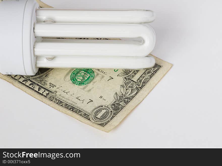 Energy saving bulb on the banknote background