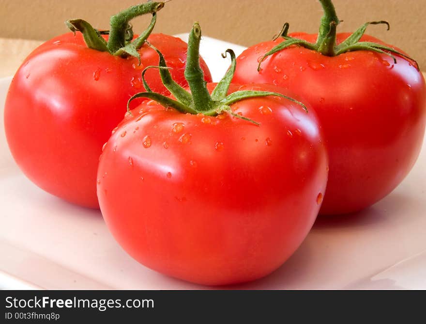 Fresh Vine Ripened Tomatoes on a white plate. Red Tomatoes hand picked for the grocery market These will add fresh ingredients to your vegetable list. Fresh Vine Ripened Tomatoes on a white plate. Red Tomatoes hand picked for the grocery market These will add fresh ingredients to your vegetable list