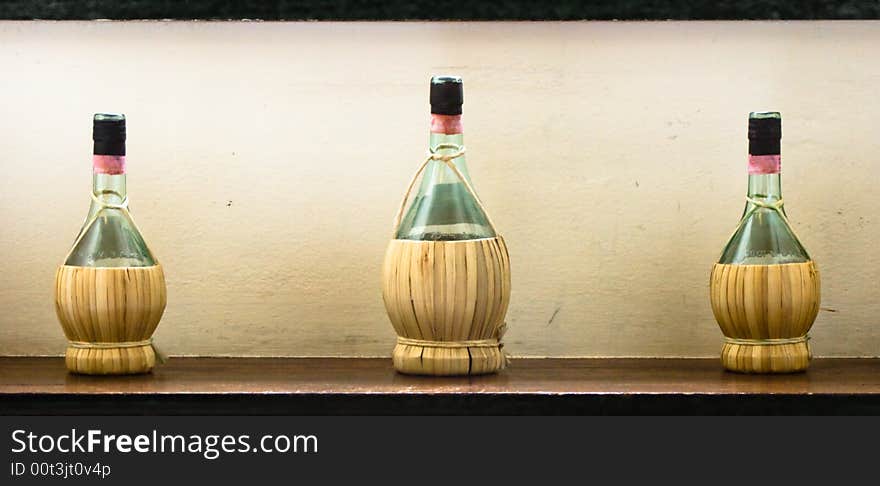 Three tipical italian wine bottles with straw covering. Three tipical italian wine bottles with straw covering