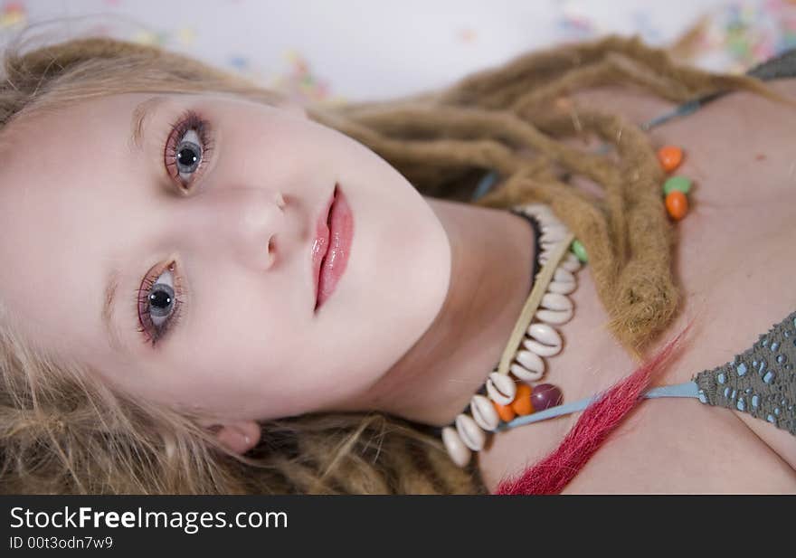 A pretty blond girl with dreads laying on the floor, surrounded by candies. A pretty blond girl with dreads laying on the floor, surrounded by candies