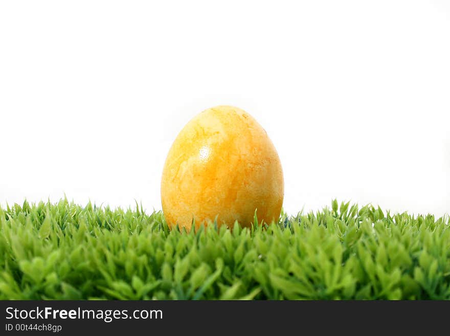 A yellow easter egg on grass