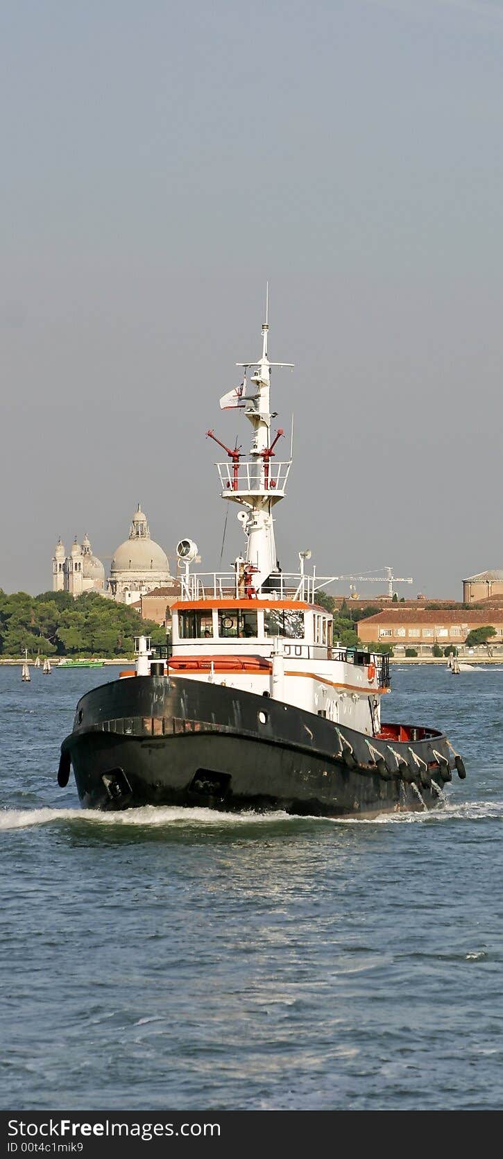 A tugboat in the ocean going through the port. A tugboat in the ocean going through the port