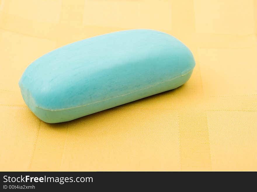 Piece of blue soap on yellow towel